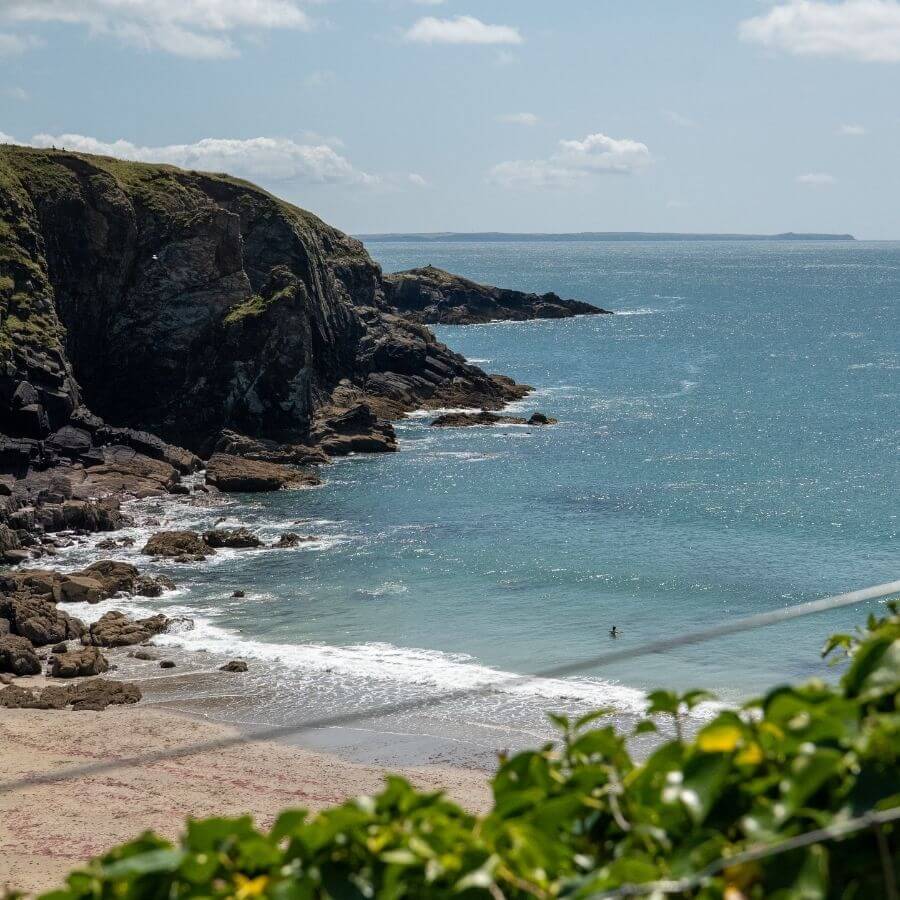 Coastal path overlooking Caerfai Bay near St Davids, with views across the Pembrokeshire coastline towards St Non's Chapel.